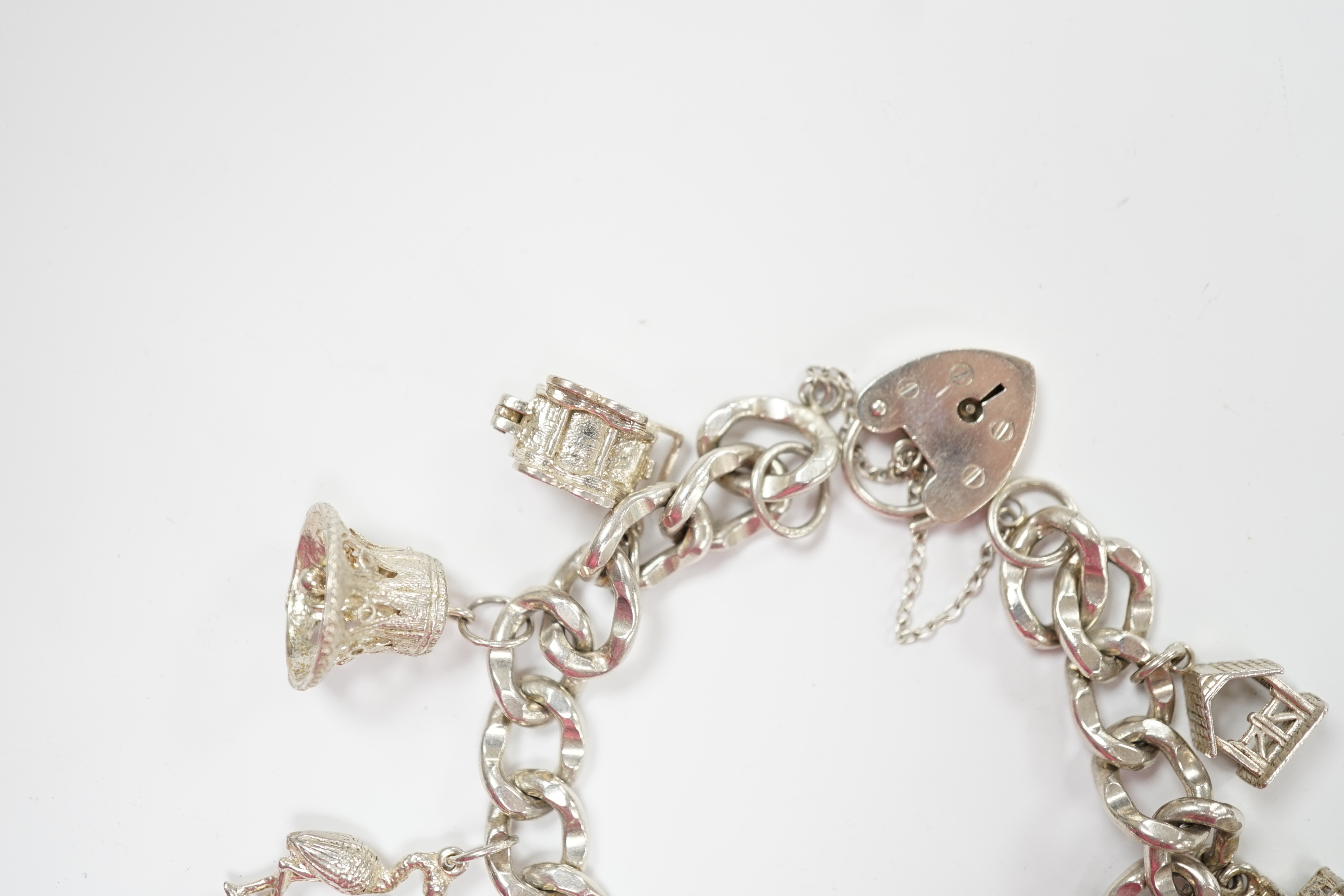 A modern silver charm bracelet, hung with nine assorted charms.